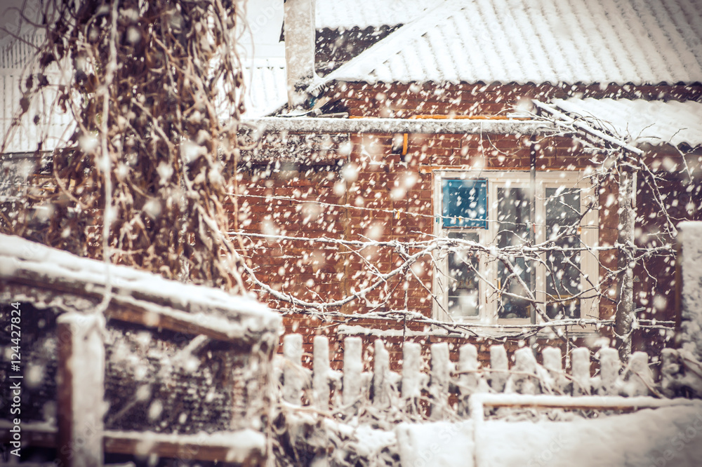 Snowfall Winter Weather in village with snowflakes and old house window moody seasonal scene Snow storm with trendy colors