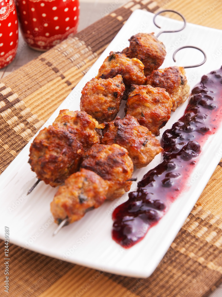 Lamb meatballs baked on skewers with cranberry sauce