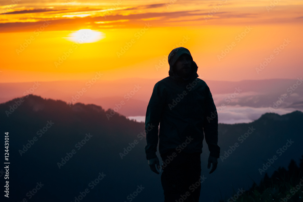 Man Traveler silhouette walking alone outdoor with sunset mountains on background Travel Lifestyle and survival concept