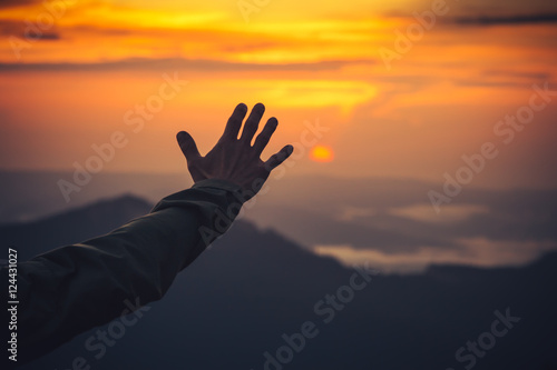 Touch the Sky concept Man Hand and Sunset mountains on background Travel Lifestyle Expression
