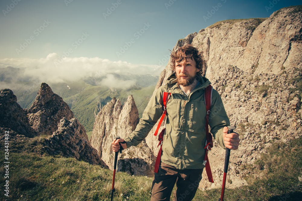 Young Man with backpack hiking outdoor Travel Lifestyle survival concept with rocky mountains on background Summer vacations