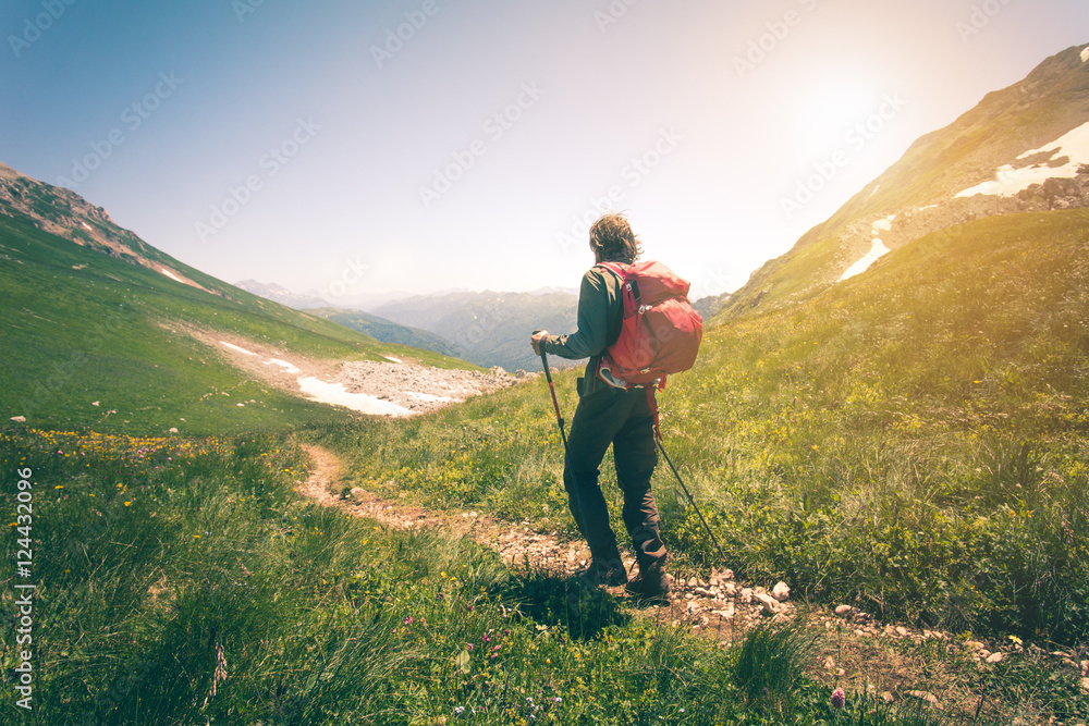 Young Man with backpack mountaineering outdoor Travel Lifestyle concept mountains on background Summer vacations journey