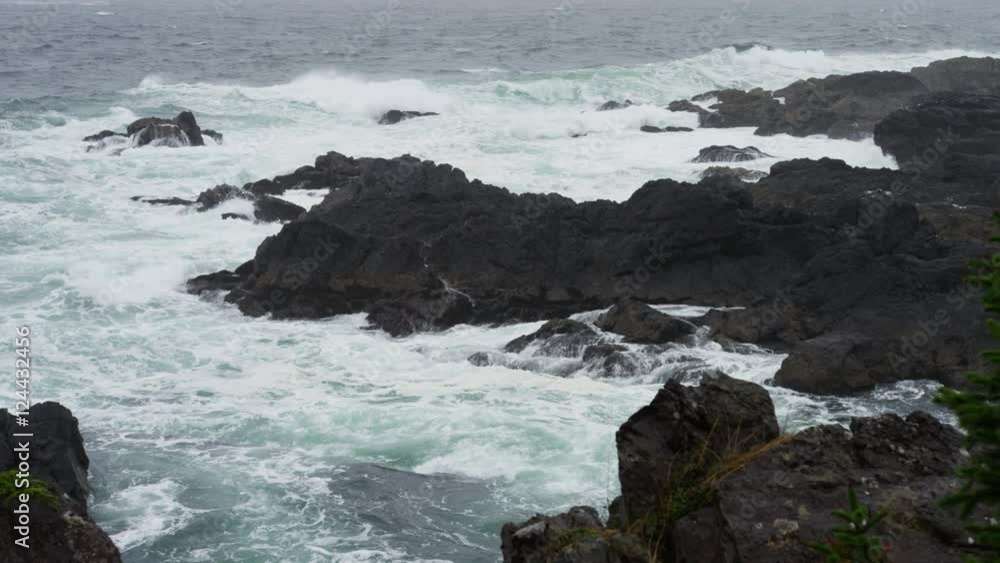 Rain gusts over a stormy ocean shoreline with waves crashing over black rocks as a seagull flies out to sea. In slow motion. 4k. Rain gusts over a stormy ocean shoreline with waves crashing over black rocks as a seagull flies out to sea. In slow motion. 4k.