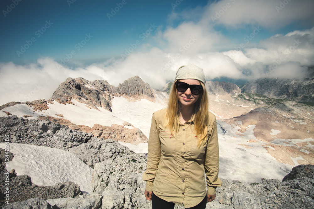 Young Woman hiker on summit with cloudy mountains landscape on background outdoor Travel Lifestyle concept Summer journey vacations