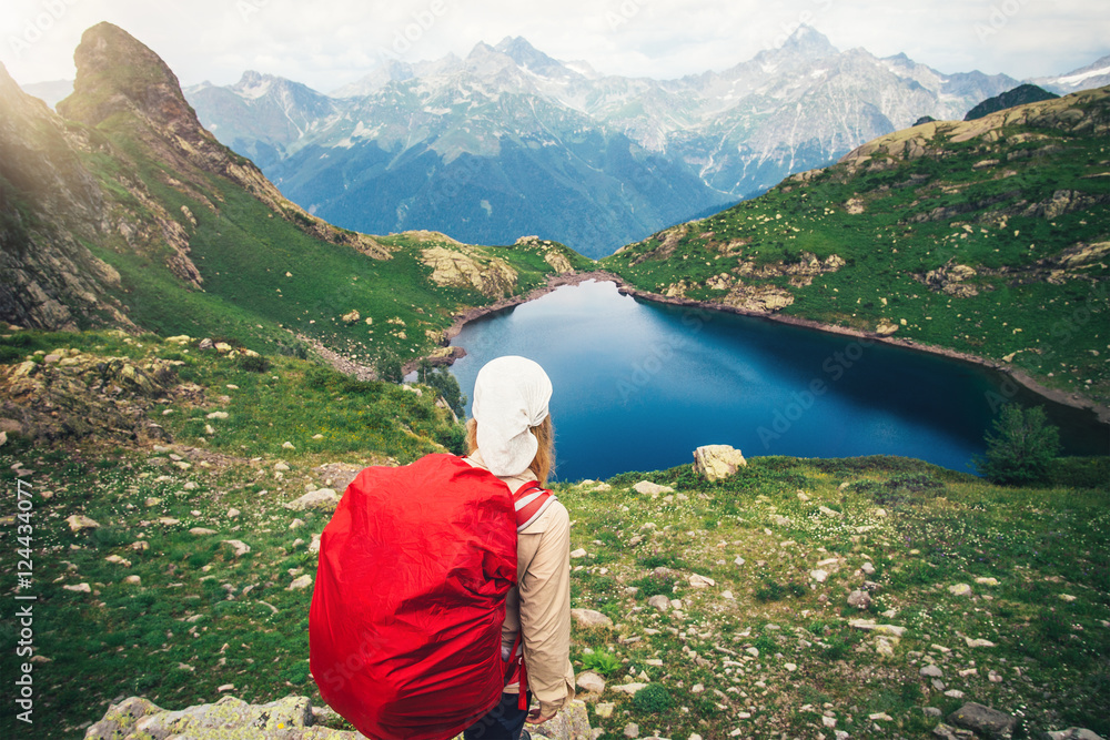 Woman Hiker with red backpack mountaineering Travel Lifestyle concept lake and mountains landscape on background journey vacations outdoor