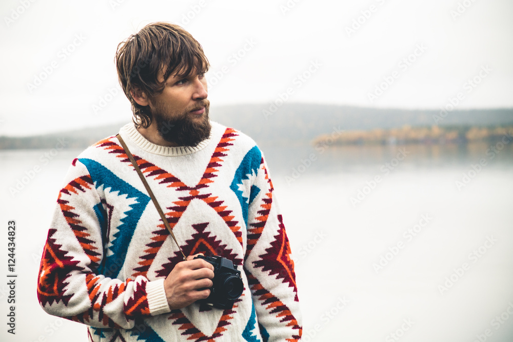 Young Man bearded with retro photo camera Fashion Travel Lifestyle wearing knitted sweater clothing outdoor foggy nature on background Young Man bearded with retro photo camera Fashion Travel Lifestyle wearing knitted sweater clothing outdoor foggy nature on background