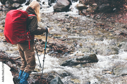Traveler Woman with backpack hiking Travel Lifestyle concept active vacations outdoor river on background rainy moody weather