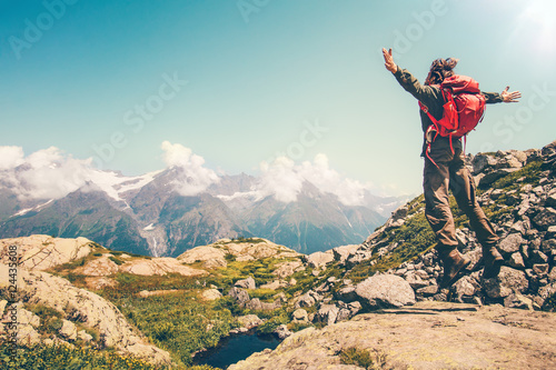 Happy Man with red backpack jumping hands raised mountains landscape on background Lifestyle Travel active summer vacations outdoor.