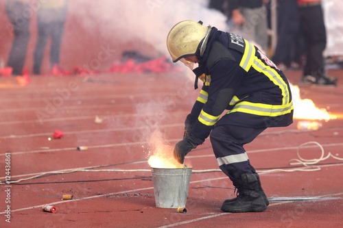Firefighter putting down football fans' torches fire