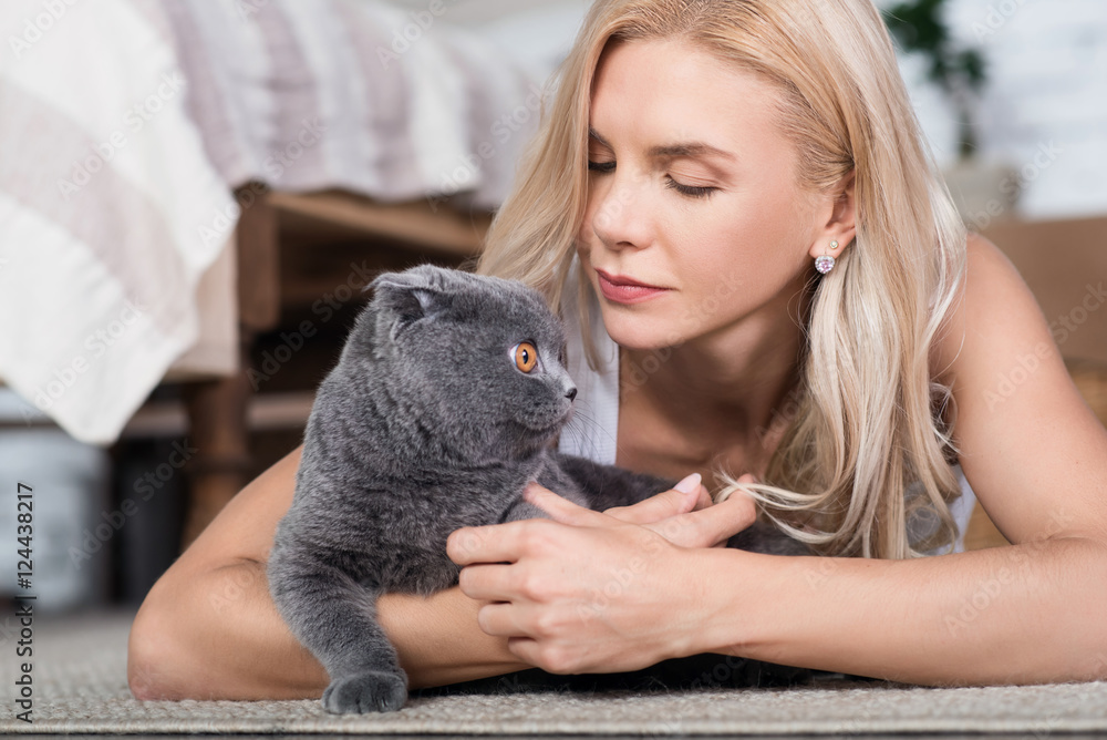 Blond woman lying on floor with cat