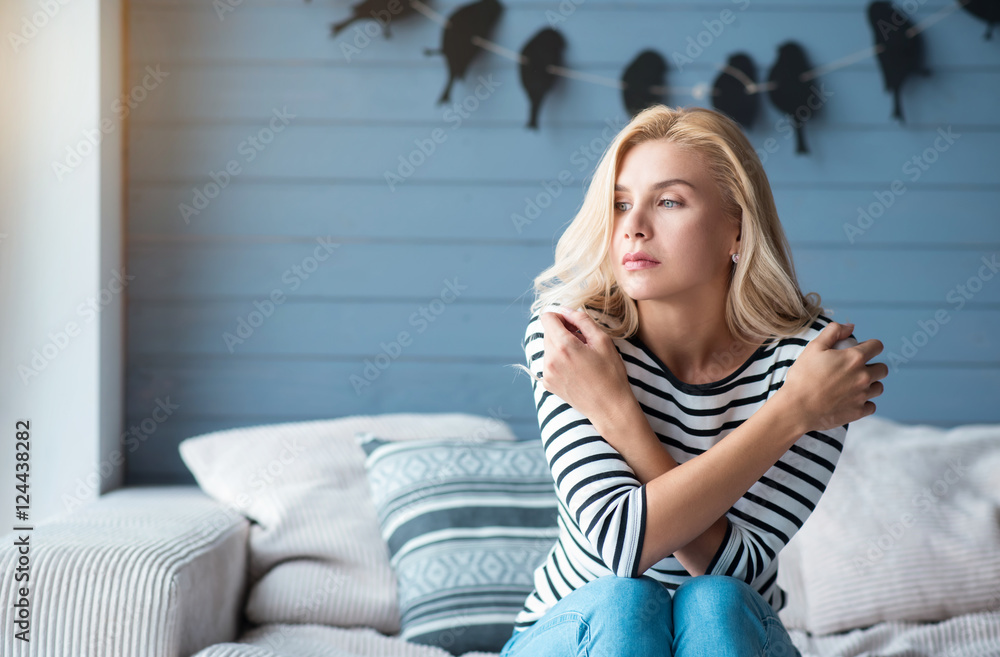Blond woman with crossed arms on couch Blond woman with crossed arms on couch