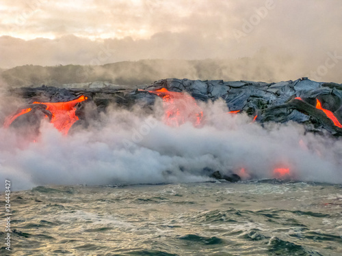 Scenic view from boat of Kilauea Volcano in Hawaii Volcanoes National Park, while erupting lava into Pacific Ocean, Big Island, Hawaii, United States.