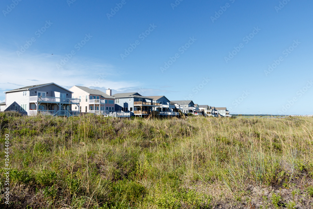 Luxury beach vacation houses across the green sand dunes, in Sunset Beach, North Carolina. Luxury beach vacation houses across the green sand dunes, in Sunset Beach, North Carolina.