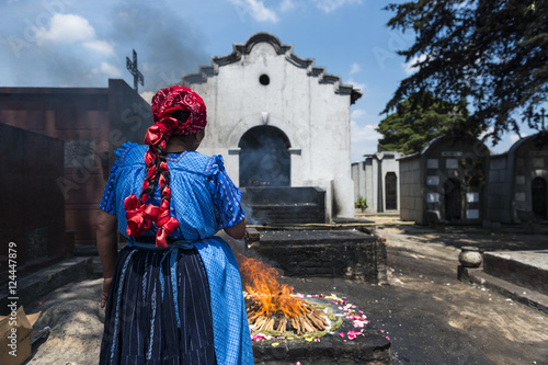  Maya woman performing a traditional mayan ritual in the cemetery of the town of Chichicastenango, in Guatemala photo