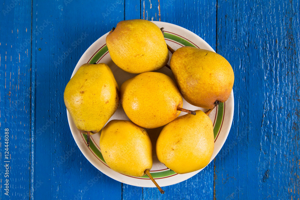 Fresh ripe organic yello pears on blue rustic wooden table, natural background, diet food.