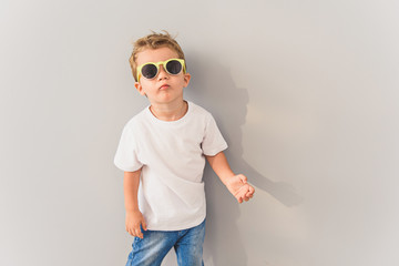 Little boy in sunglasses posing in studio