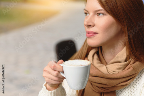 Dreamful young woman relaxing in cafe