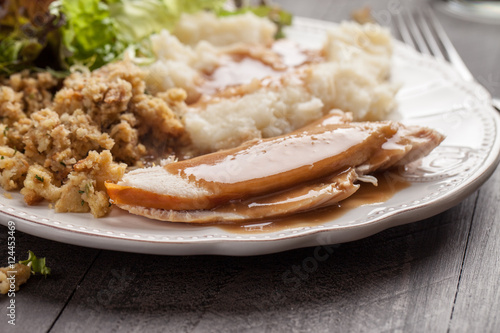 Oven roasted turkey Thanksgiving platter with mashed potatoes, gravy, salad, and stuffing side view