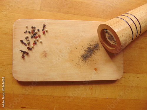 Pepper on cutting board with peppermill photo