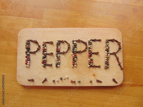 Pepper written on cutting board with pepper 
