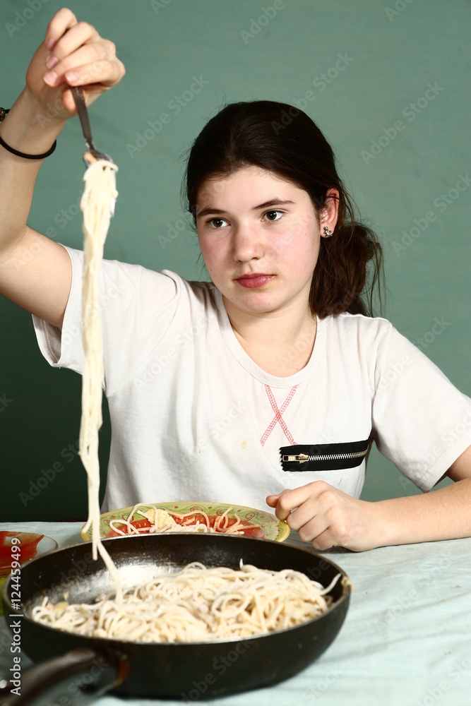 girl eating spahgetty. Spaghetty on the frying pan girl eating spahgetty. Spaghetty on the frying pan