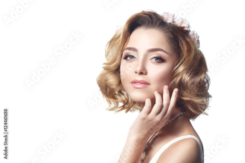 Beauty portrait of a cute blonde with the laying of the waves and the make-up isolated on white background.