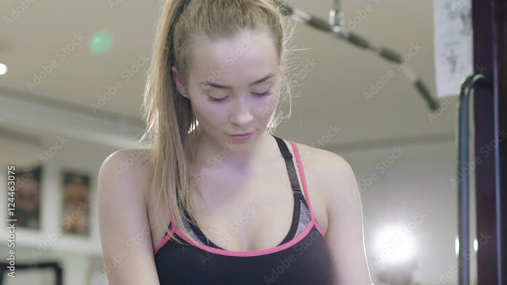 Fitness healthy woman standing and looking at camera in the gym. Slowly Fitness healthy woman standing and looking at camera in the gym. Slowly