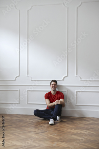 Smiling man sitting inside a room