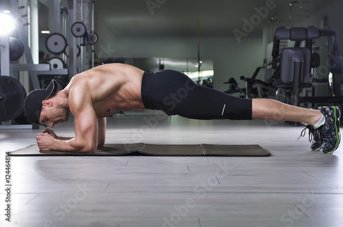 Konstfotografi Handsome powerful athletic man doing plank exercise