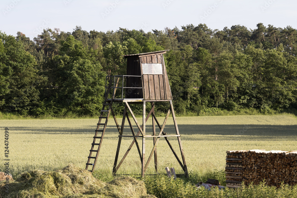 Wooden watch tower on the green farm field in Germany Wooden watch tower on the green farm field in Germany