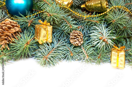 Christmas tree branches with cones, gifts and toys on a white ba