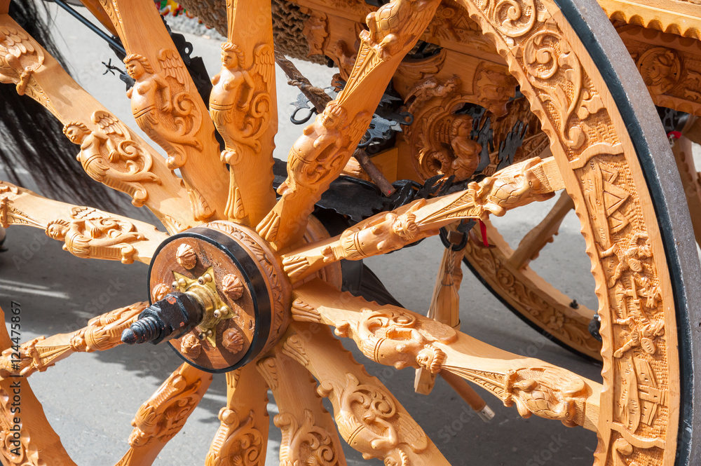 Close-up view of a wooden carved wheel of a typical sicilian cart during a folkloristic show