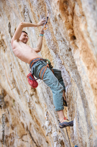 Male rock climber on a challenging route on a cliff 