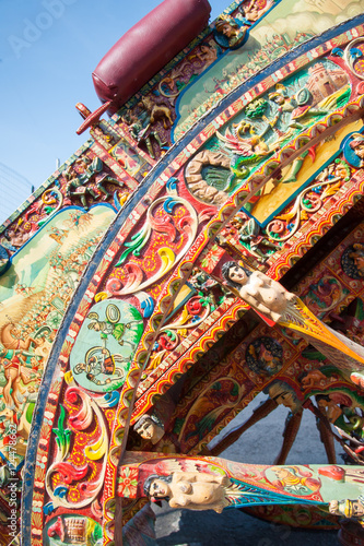 Close-up view of a colorful wheel of a typical sicilian cart during a folkloristic show