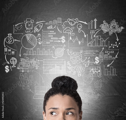 African girl's head and business icons on blackboard