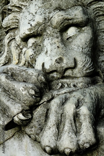 Statue of relaxing or sleeping stone lion with forepaws under his head in arboretum Mlynany, Slovakia © zayacsk