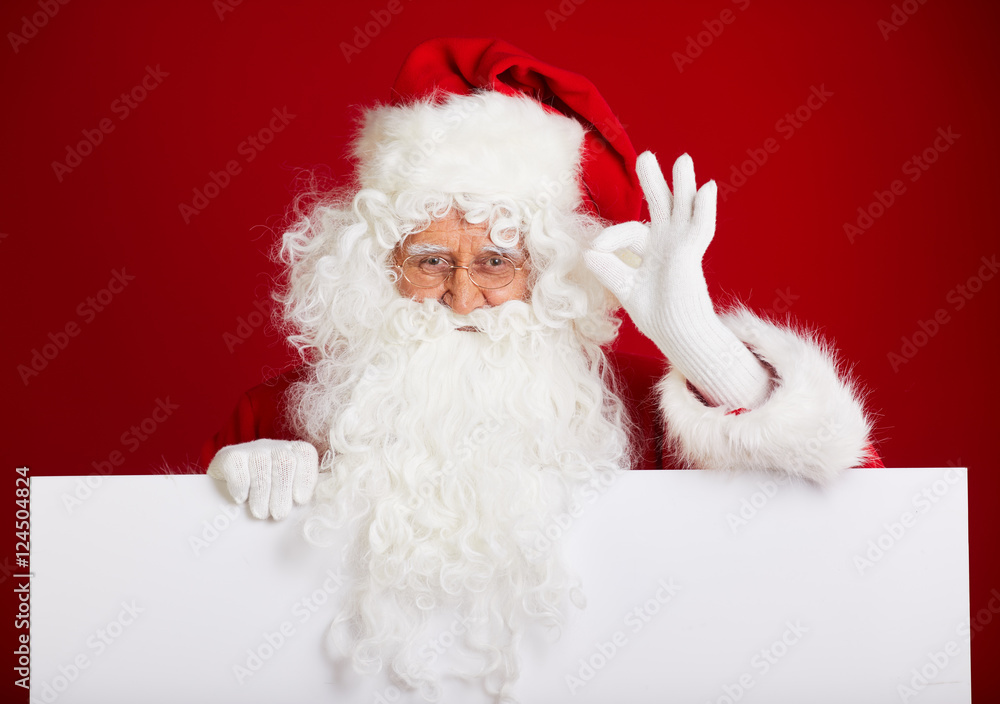 Santa Claus pointing in blank advertisement banner isolated on r