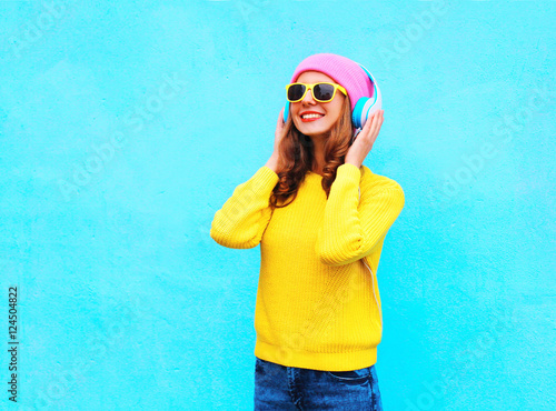 cool smiling girl in headphones listening to music wearing color