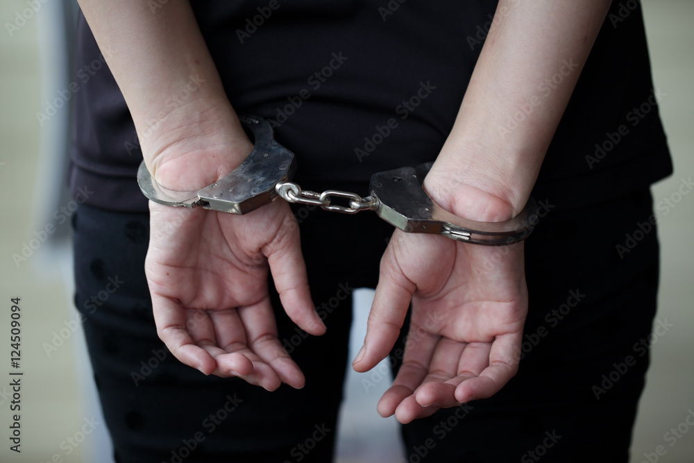 Criminal in handcuffs arrested for crimes.