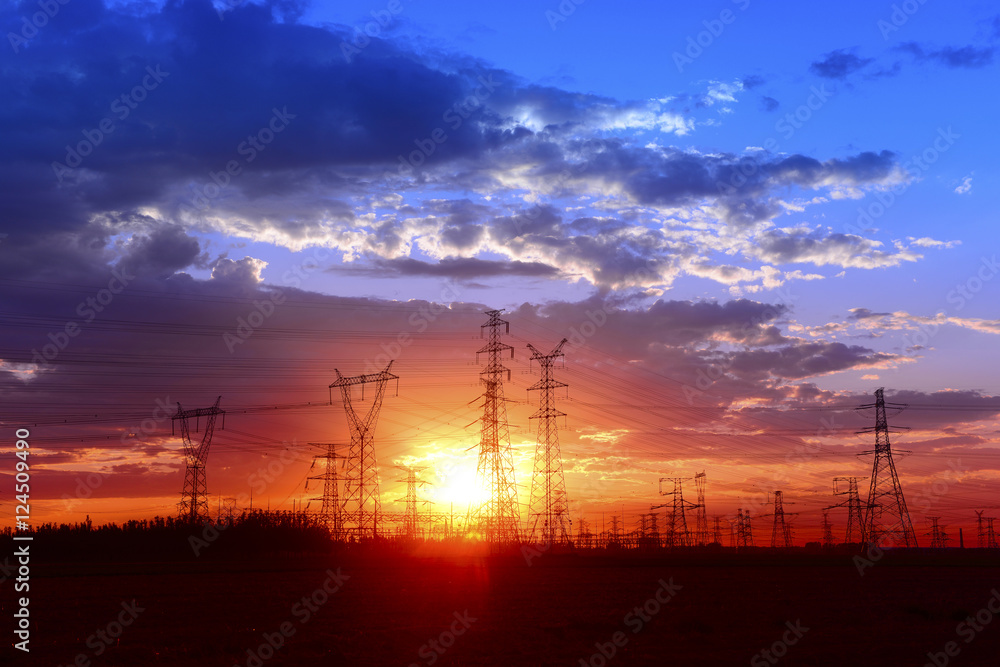 Many high voltage towers under the sunset