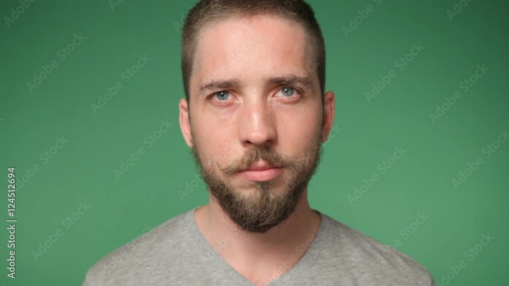 Young serious man with the mustache and beard in a gray shirt, chroma key green screen background, zoom in Young serious man with the mustache and beard in a gray shirt, chroma key green screen background, zoom in