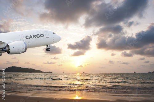 Cargo airplane taking off at sunset
