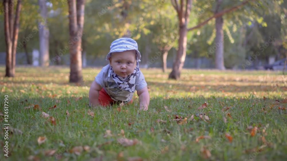 Baby in panama crawling on the grass in the park. Baby in panama crawling on the grass in the park.