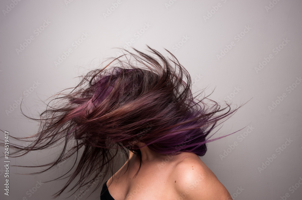 Obraz premium Stop action photograph of a beautiful woman with brunette hair creating motion with her hair.
