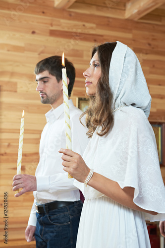 Orthodox wedding ceremony. man and woman with candles at church photo