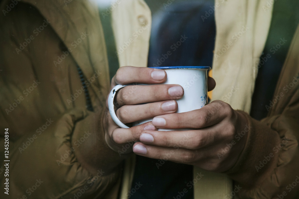hands holding the cup after the window hands holding the cup after the window