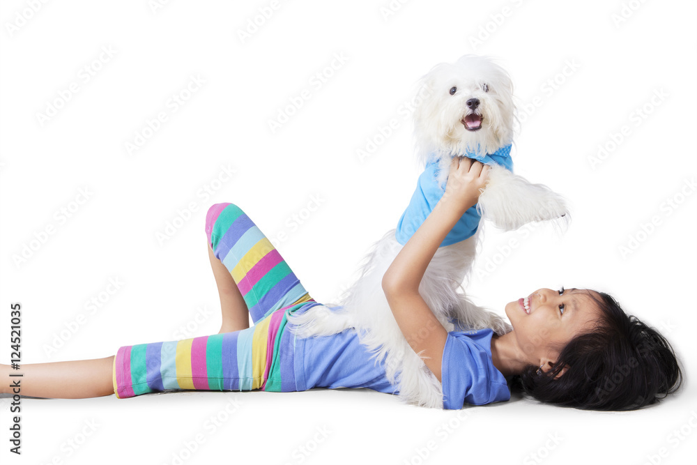 Little girl playing with a maltese dog