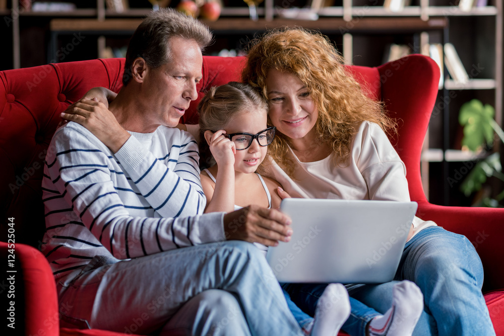 Girl sitting in front of the laptop with her grandparents Girl sitting in front of the laptop with her grandparents