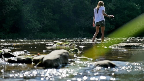 A girl is walking in a river in Bieszczady, Poland. photo