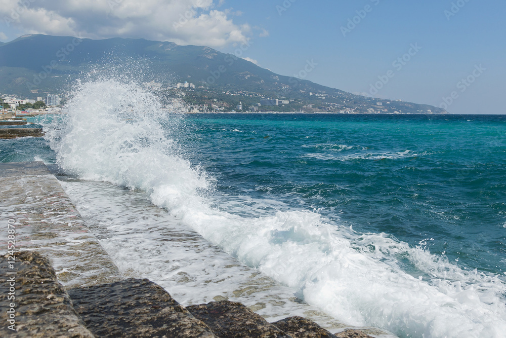 Foamy wave is incident on the plate. On the East side of Yalta, Crimea